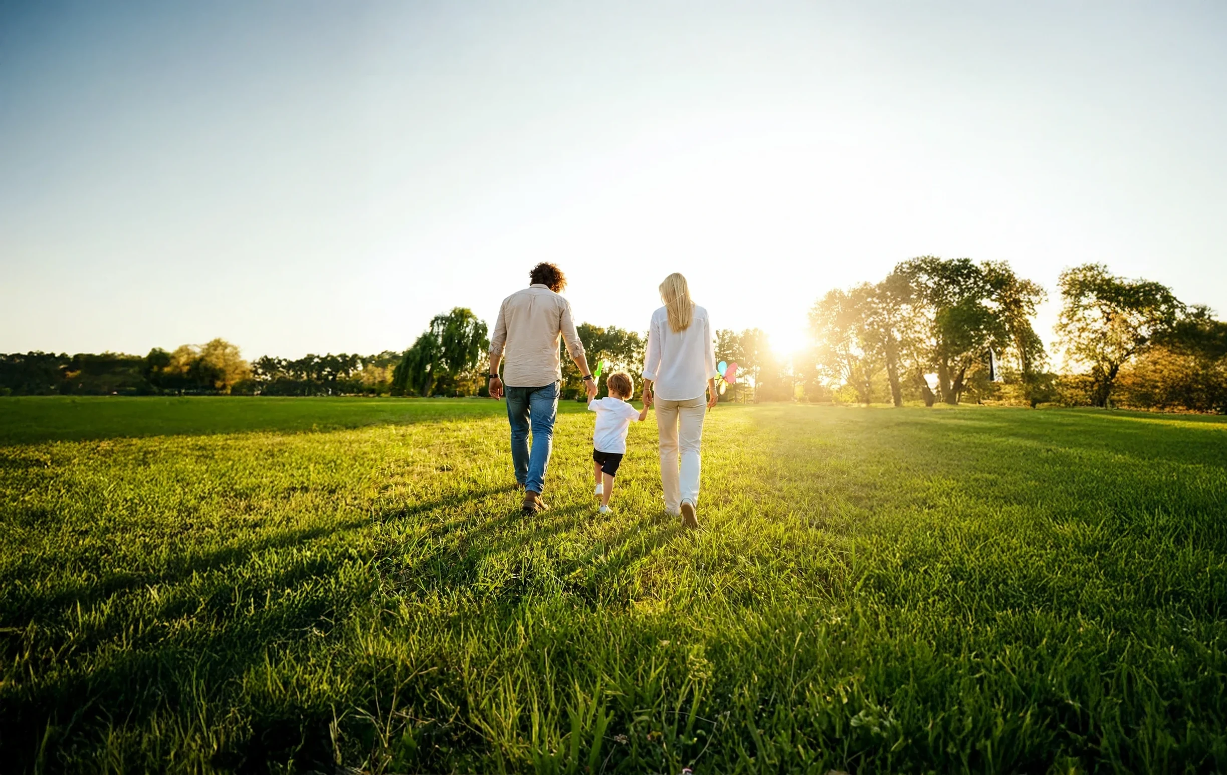 Family walking through countryside at sunset, suggesting calm renewal after separation